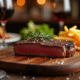 Steak appétissant sur planche en bois avec frites et vin rouge